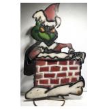 Metal Grinch in a chimney yard decor