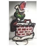 Metal Grinch in a chimney outdoor yard decor