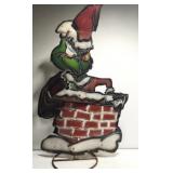 Metal Grinch in a chimney yard decor