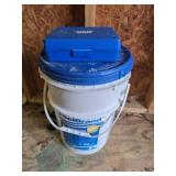 Used bucket of chlorine tablets and water tester