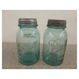 Two blue Ball mason jars with lids, one is zinc,