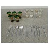 Five emerald green and gold shot glasses, one