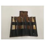 Six straight razors in an old leather pouch / in