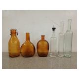Six assorted glass bottles, three are Amber