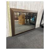 rectangular wall mirror with a dark wood frame and
