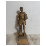 golden colored soccer dribbler statue