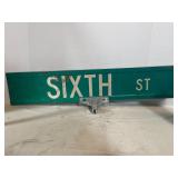 vintage green metal street sign reading 'SIXTH ST'