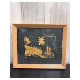 Framed straw pucture depicting a tropical coastal