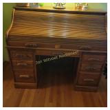 Classic oak roll-top desk featuring a tambour