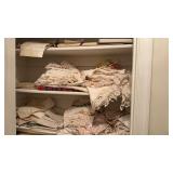 3 shelves of linens, tablecloth, hand towels,