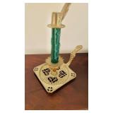 Antique brass candlestick, with a green candle,