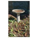 Concrete birdbath on the side of the house