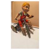 Antique wind up 10 toy boy on a bicycle with a