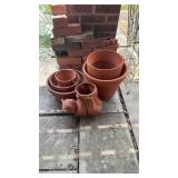 Group of clay pots that includes a cat holding a