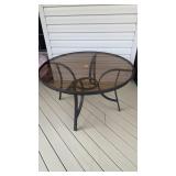 Heavy metal patio table, with a smoky glass top,