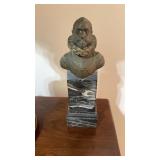 Antique bronze figure on a white swirl, black