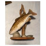 Carved and painted wood fish, with a piece of
