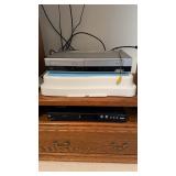 Two DVD players, and RCA DVD 6300 N with a