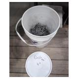 Five gallon pail 2/3 full of 4' Finish Nail