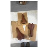 (3) brown bike seats/saddles