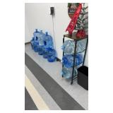 Three-tier rolling water jug storage rack with a