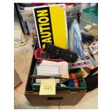 Box of office supplies and caution sign