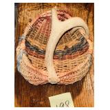 Rustic hand-woven basket featuring a naturally ..