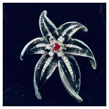 vintage silver-tone flower brooch featuring bla..