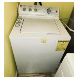White GE top-load washing machine featuring a ..