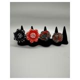 A Collection of Four Plastic Floral Rhinestone Rin