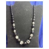 beaded necklace featuring faceted dark and clear
