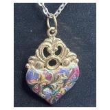 gold-tone pendant necklace featuring an ornate,