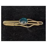 gold-tone tie clip or stock pin featuring a