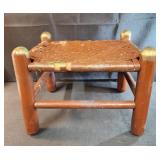 vintage wooden footstool with woven seat.
