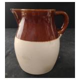 Stoneware pitcher 2 tome brown. Has a chip-see