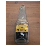 melted, flattened Cerveza Extra beer bottle