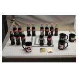 Assortment Of Vintage Coke Bottles And Coffee Mugs