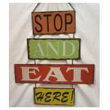 Hanging metal sign. Stop and Eat Here.