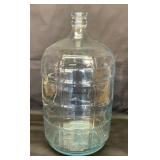 Large water bottle with blue tint. 20 inches tall.