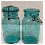Two green quart Ball jars with lid clips