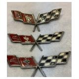 Three older metal Corvette emblems