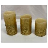 Three battery operated gold glitter candles