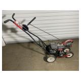 Vintage gas-powered lawn edger with a red and bla.