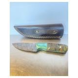 Fixed-blade Damascus steel knife featuring a vibr.