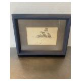 Framed ink drawing of a coastal lighthouse buildi.