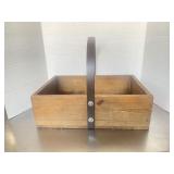 Rustic wooden caddy basket with a dark metal fixe.