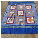 Handcrafted sports-themed patchwork quilt featuri.