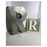 Two decorative metal signs featuring the letter 
