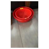 Four large red plastic strainers