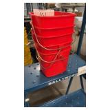 Five small red sanitizing rag buckets
